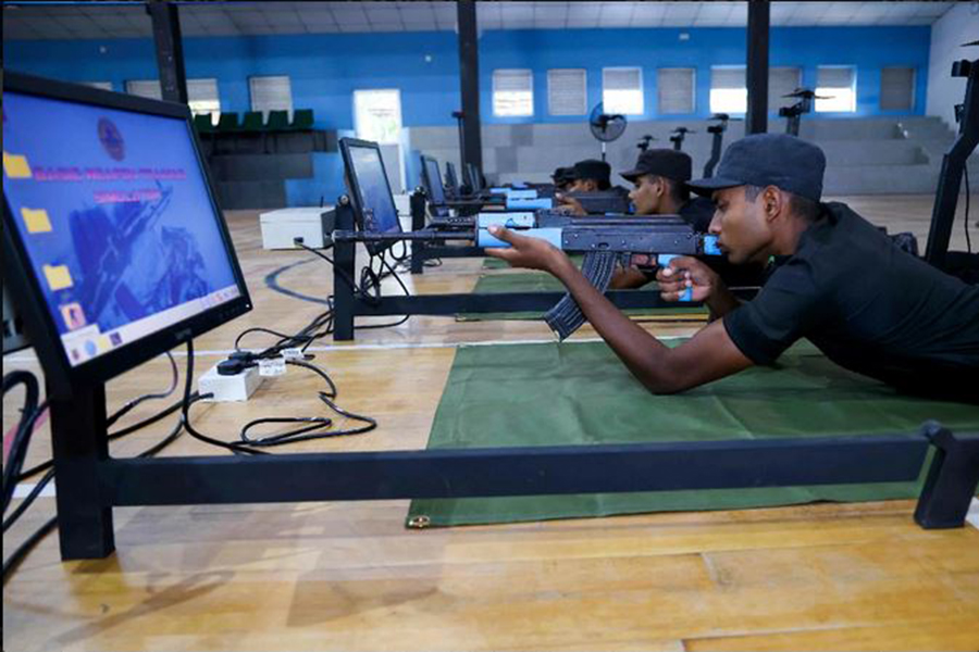 An airman sanitizes indoor shooting stations.